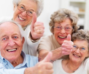 Group of older people showing thumbs up